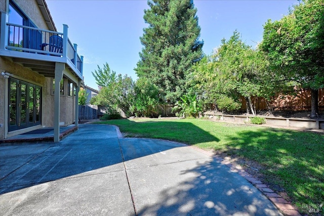 view of yard featuring a balcony and a patio area