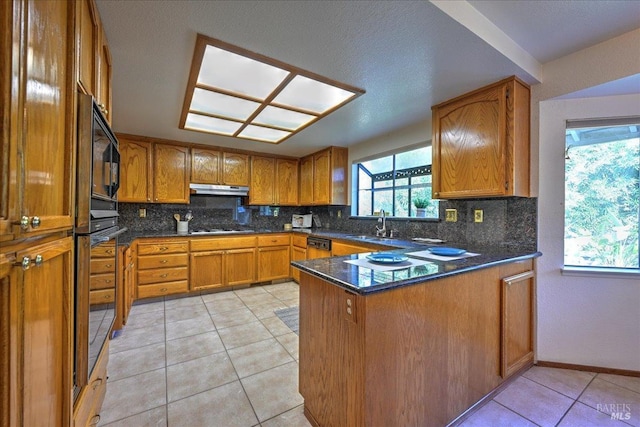 kitchen featuring kitchen peninsula, gas cooktop, sink, light tile patterned floors, and dark stone countertops