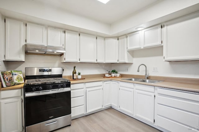 kitchen with gas range, sink, white cabinets, and light hardwood / wood-style floors