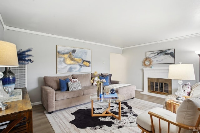 living room featuring a brick fireplace, wood-type flooring, and ornamental molding