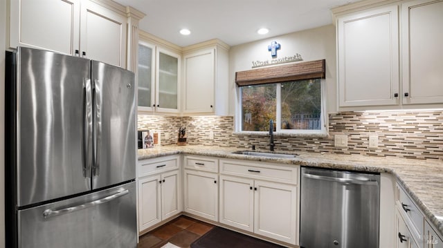 kitchen featuring tasteful backsplash, stainless steel appliances, sink, and light stone counters