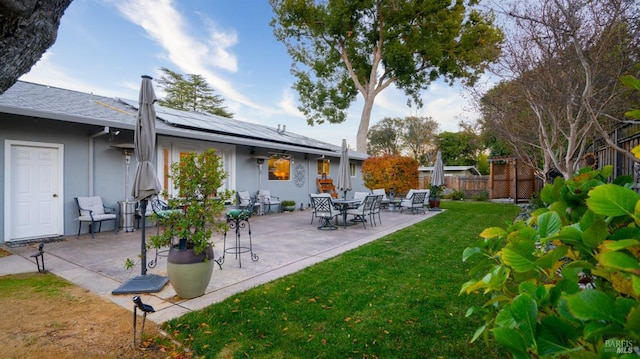 exterior space featuring a patio area, a yard, fence, and solar panels