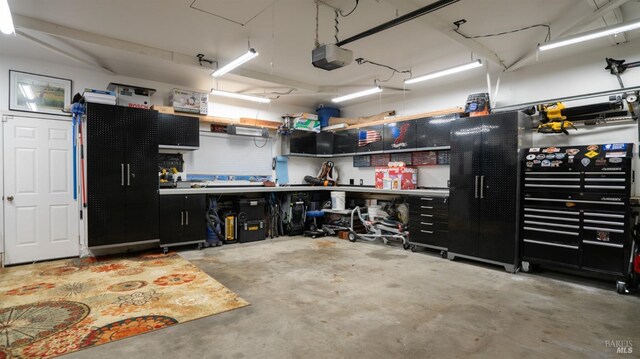 garage with a garage door opener and a workshop area