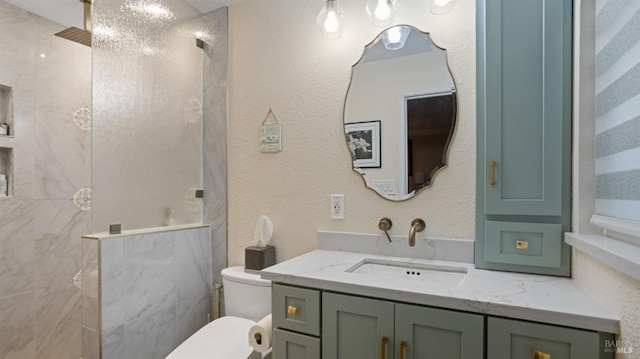 full bath featuring toilet, a textured wall, walk in shower, and vanity