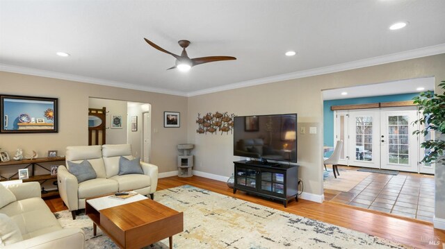 living room featuring wood-type flooring, crown molding, ceiling fan, and french doors