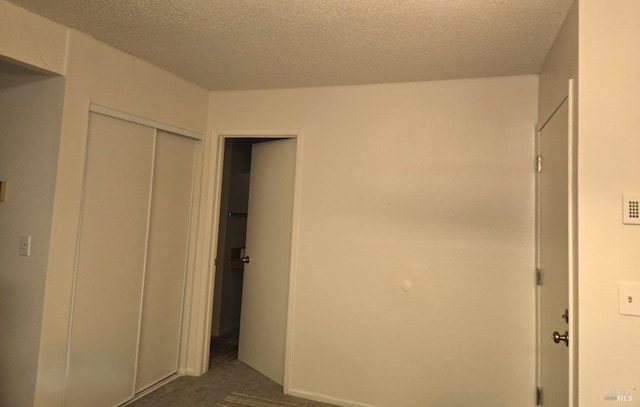 unfurnished bedroom featuring a textured ceiling and a closet