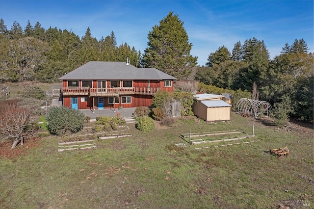 rear view of house featuring a wooden deck and a storage shed