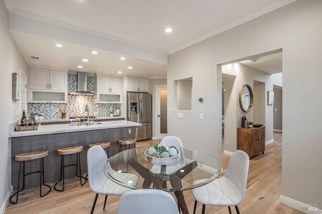 dining room featuring crown molding and light hardwood / wood-style flooring