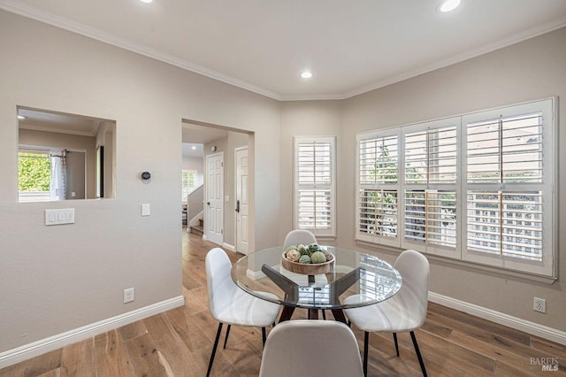 dining space with ornamental molding, a wealth of natural light, and wood-type flooring