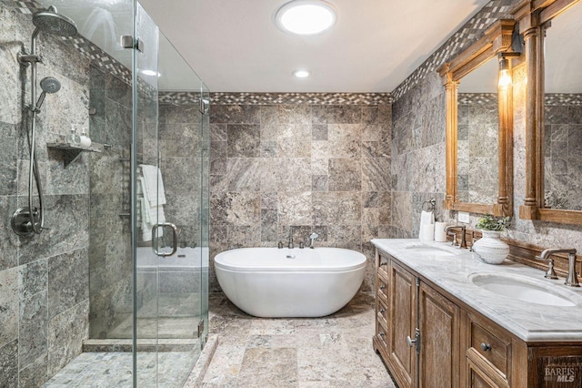 bathroom with tile walls, shower with separate bathtub, and vanity