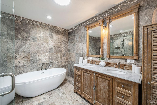 bathroom featuring tile walls, a bath, and vanity