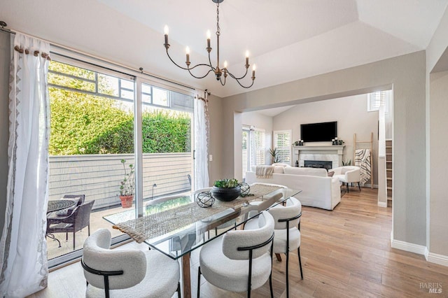 dining area with a fireplace, a healthy amount of sunlight, and light hardwood / wood-style flooring