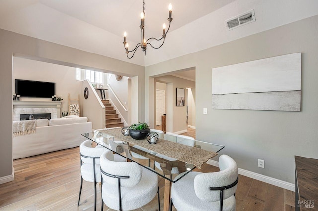 dining area featuring light wood-type flooring and an inviting chandelier