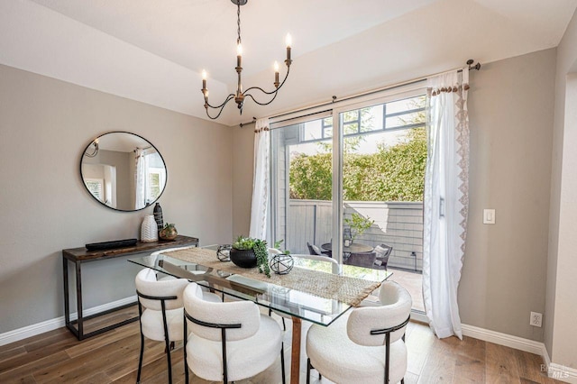 dining room with dark hardwood / wood-style flooring and a notable chandelier