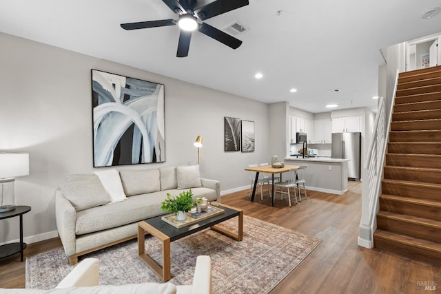 living room with ceiling fan, hardwood / wood-style floors, and sink