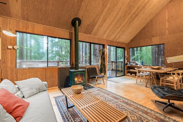 sunroom with vaulted ceiling, a wood stove, and wooden ceiling