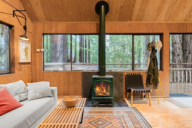 sunroom / solarium featuring a wood stove, wood ceiling, and lofted ceiling