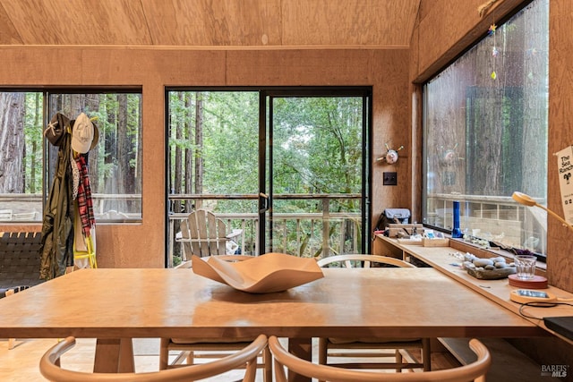 dining area featuring wooden ceiling and wood walls