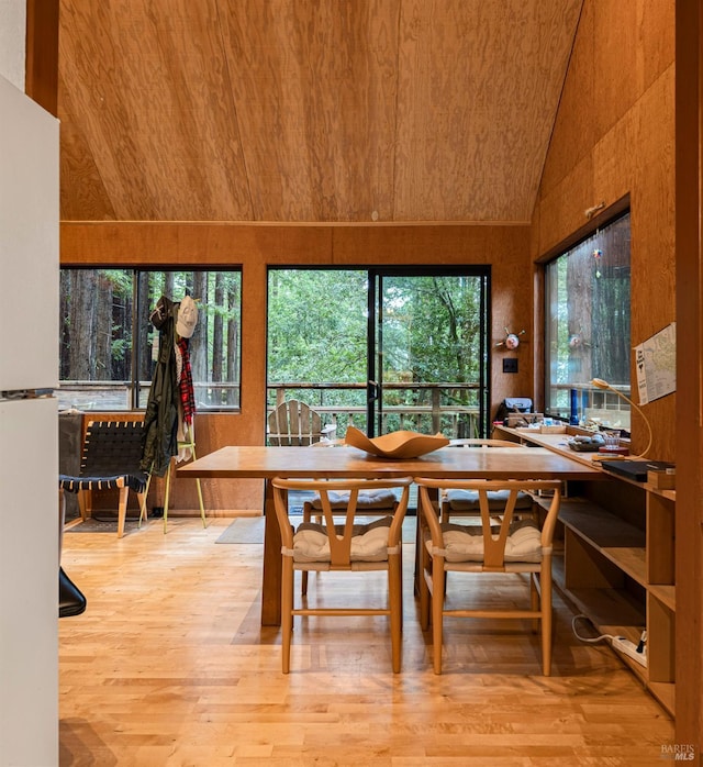 dining room featuring wooden ceiling, light hardwood / wood-style floors, and lofted ceiling