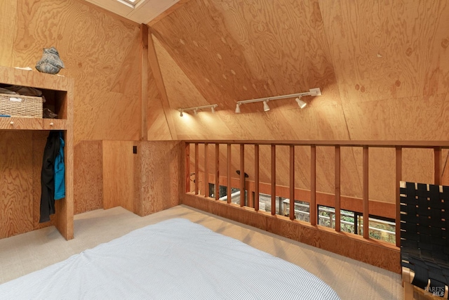 bedroom featuring wood walls and track lighting