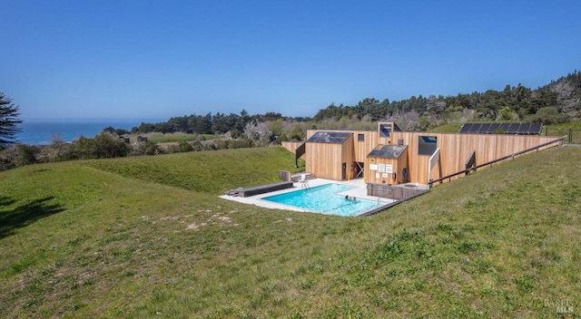 view of pool featuring a lawn and an outdoor structure