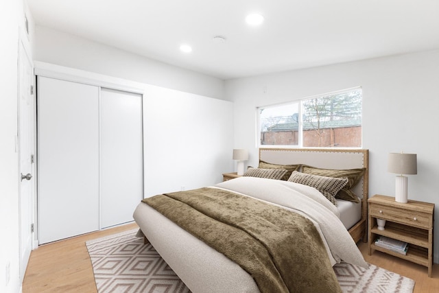 bedroom featuring light wood-style floors, a closet, and recessed lighting