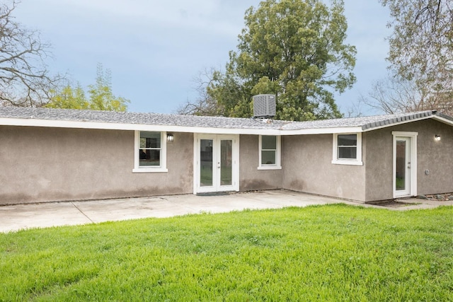 back of house with a patio, central air condition unit, french doors, a lawn, and stucco siding