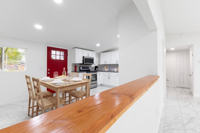 dining area featuring marble finish floor, baseboards, vaulted ceiling, and recessed lighting