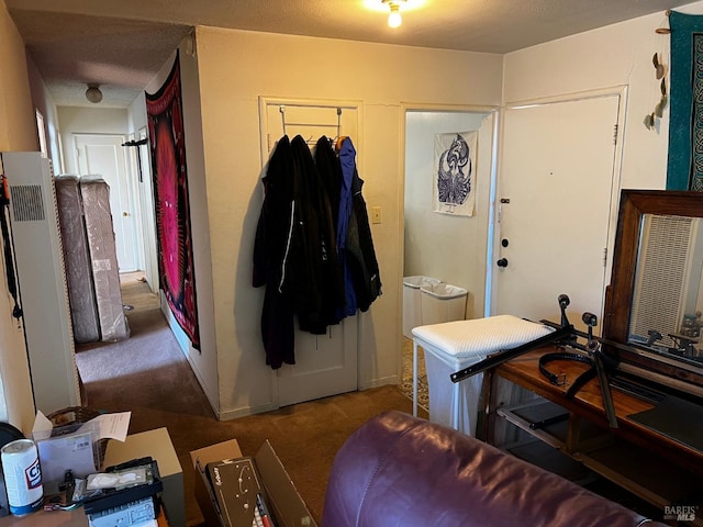 entryway with dark carpet and a textured ceiling