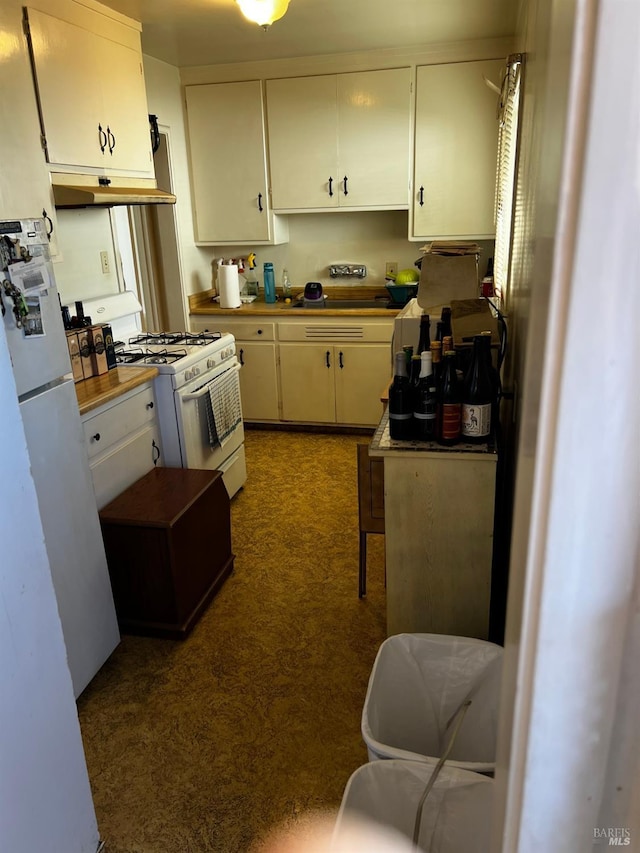 kitchen featuring white cabinets and white appliances