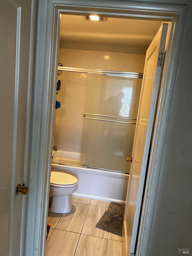 bathroom with shower / bath combination with glass door and toilet