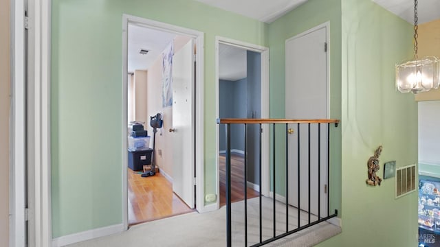 corridor with a chandelier and carpet floors