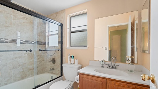 full bathroom featuring combined bath / shower with glass door, vanity, and toilet