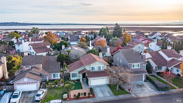 aerial view at dusk featuring a water view