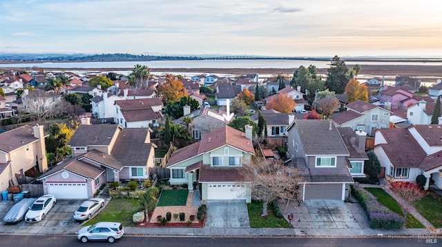 aerial view at dusk featuring a water view