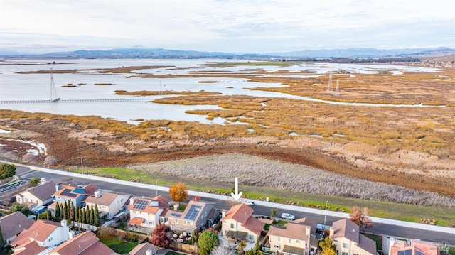 drone / aerial view featuring a water and mountain view