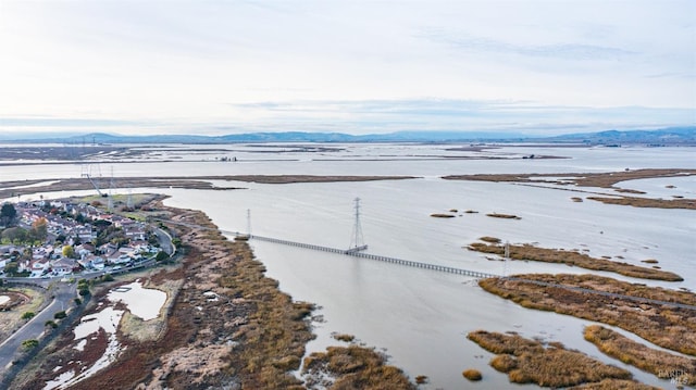 drone / aerial view featuring a water and mountain view