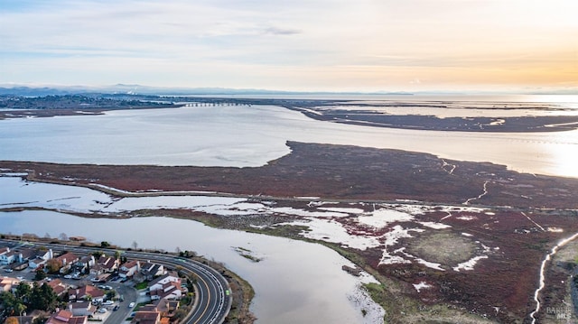 aerial view at dusk featuring a water view