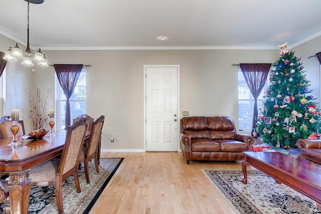 dining area with a healthy amount of sunlight, light hardwood / wood-style flooring, and crown molding