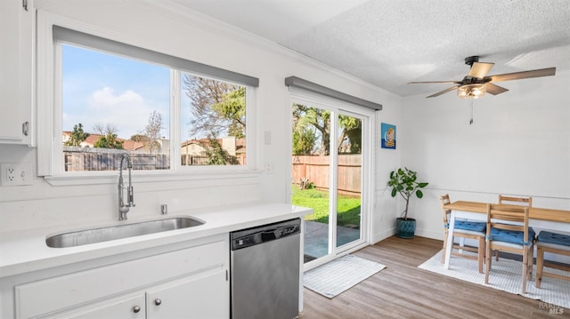 kitchen with white cabinetry, dishwasher, a textured ceiling, and sink