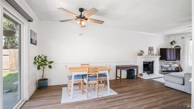 dining area with hardwood / wood-style floors, a textured ceiling, ceiling fan, and crown molding