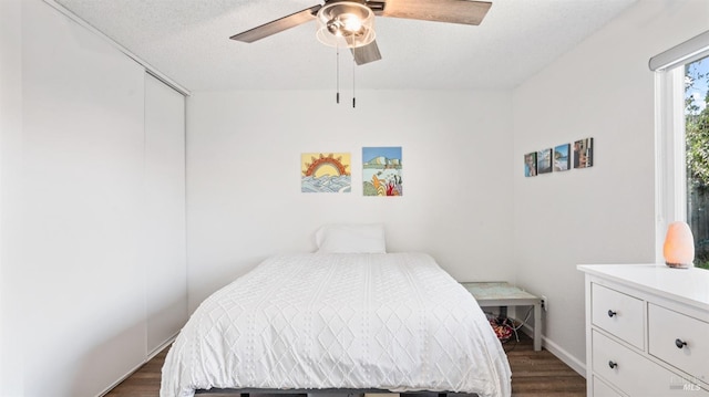 bedroom featuring ceiling fan, dark hardwood / wood-style floors, a textured ceiling, and a closet