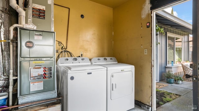 laundry area featuring washing machine and dryer and heating unit