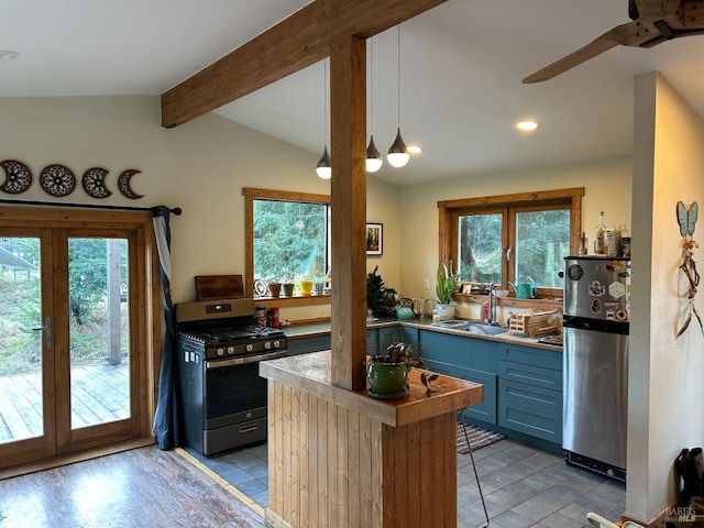 kitchen with pendant lighting, sink, stainless steel appliances, plenty of natural light, and vaulted ceiling with beams