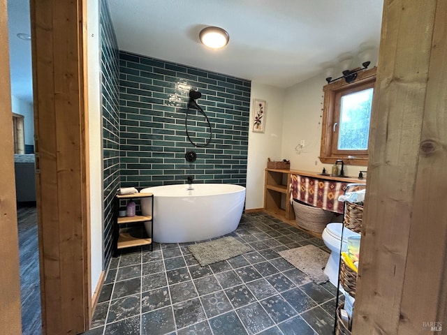 bathroom with a tub to relax in, vanity, and toilet