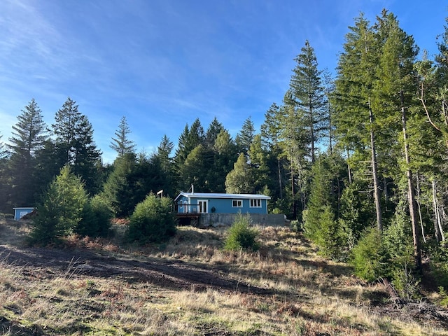 34620 Eureka Hill Rd, Point Arena, CA 95468 - view of front of home featuring a wooden deck and a forest view