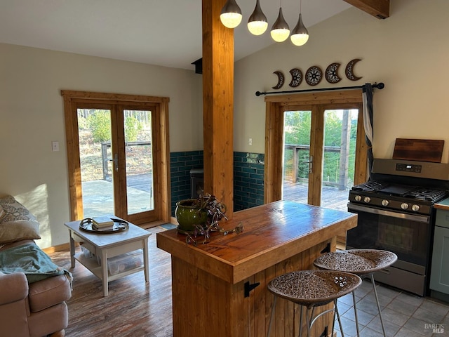 kitchen with decorative light fixtures, stainless steel gas stove, french doors, and plenty of natural light