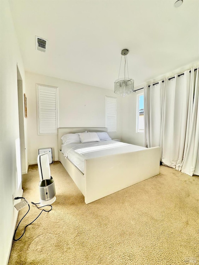 carpeted bedroom featuring a notable chandelier