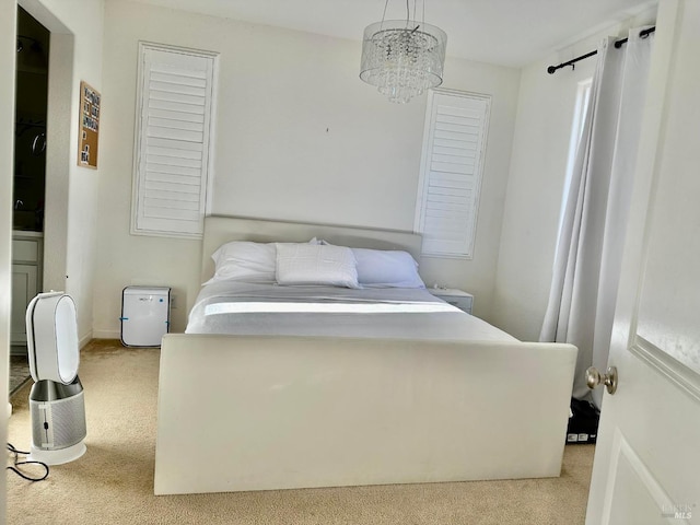 bedroom with a notable chandelier and light carpet