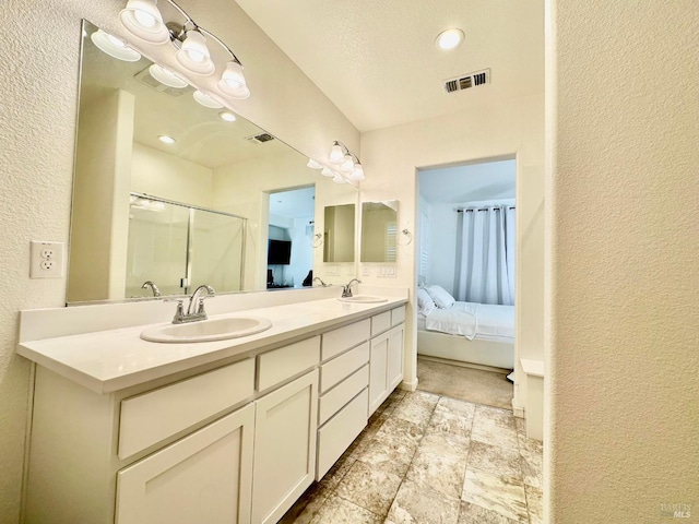 bathroom with a textured ceiling, a shower with shower door, and vanity